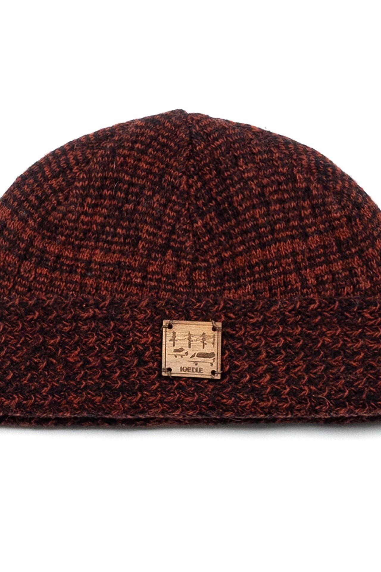 Red and brown flowing landscape short beanie by IOEDLE, shown in a close-up view highlighting its textured knit fabric.