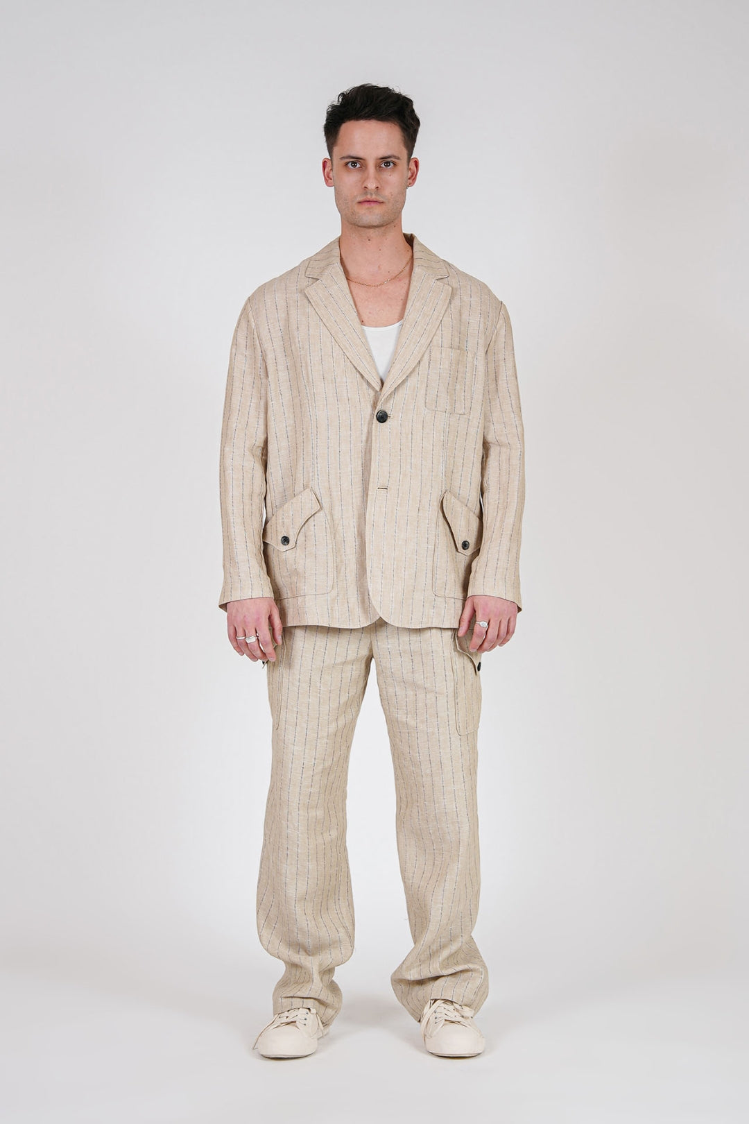 Beige linen cargo pants from IOEDLE featuring multiple pockets and a relaxed fit, shown on a model.
