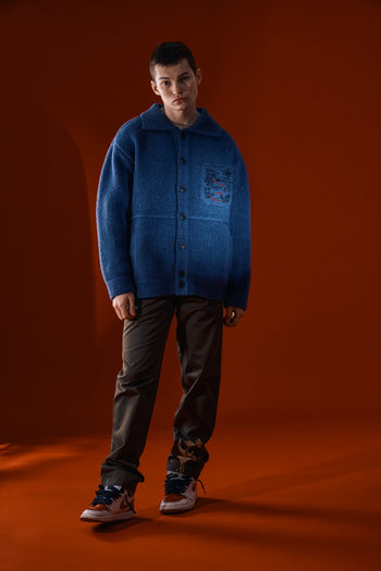 Blue IOEDLE Guide to Memories Knit Jacket displayed on a hanger with a cozy, textured knit design and front button closure.