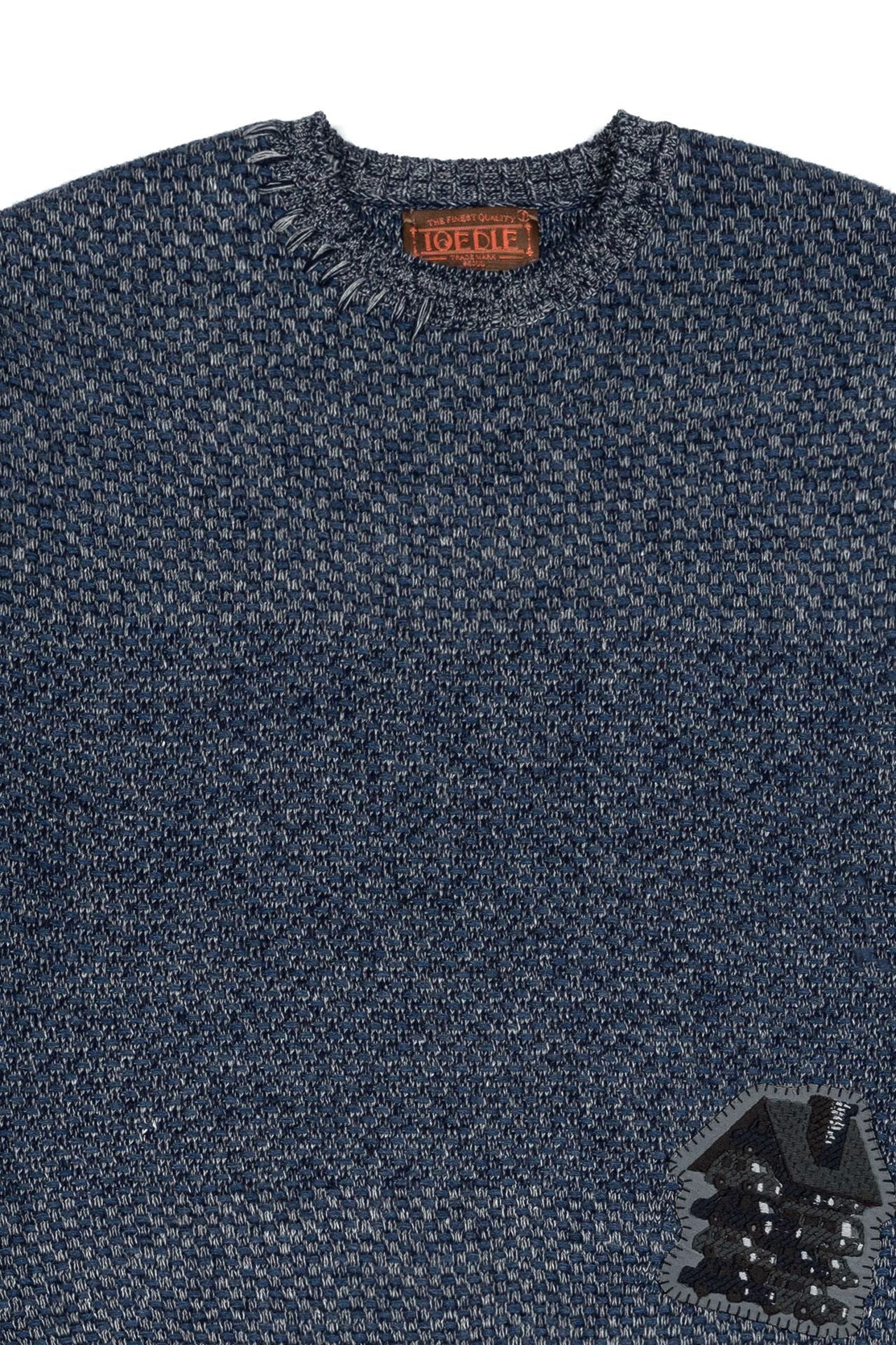 Navy IOEDLE House of Cars sweater featuring a cozy knit design and logo, displayed on a hanger against a neutral background.