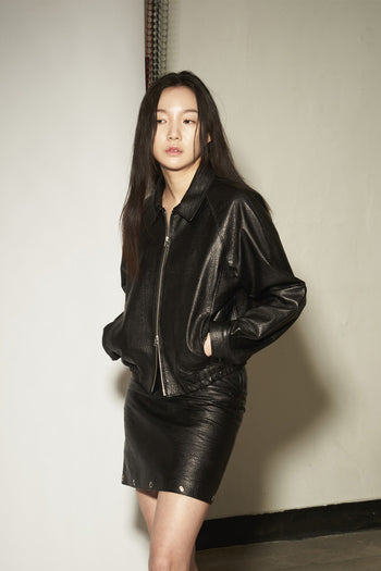 Black Lunecave lamb skin raglan jacket with long sleeves and a relaxed fit, displayed on a hanger.