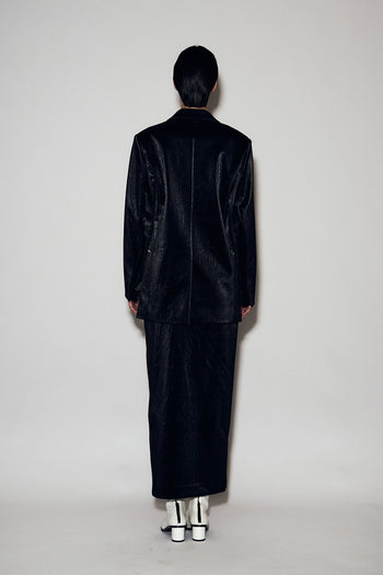 Black eco leather loose-fit jacket by Lunecave, shown on a hanger highlighting its relaxed style and soft leather texture.