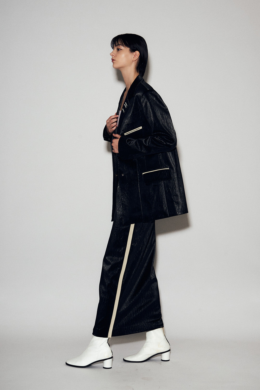 Black Eco Leather Loose-Fit Jacket by Lunecave, shown on a hanger with a relaxed fit and sleek design.
