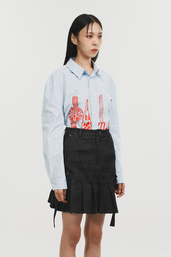 Charcoal denim pleats skirt by Phenomenon Seeper, shown from the side with a high waist and flowing pleated design.