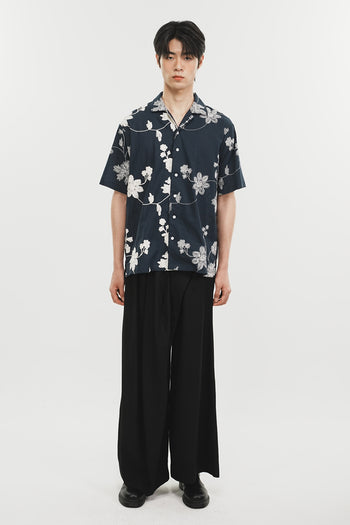 Navy Phenomenon Seeper Unbalance Flower Half Shirt displayed flat, showing its unique floral design and relaxed fit.