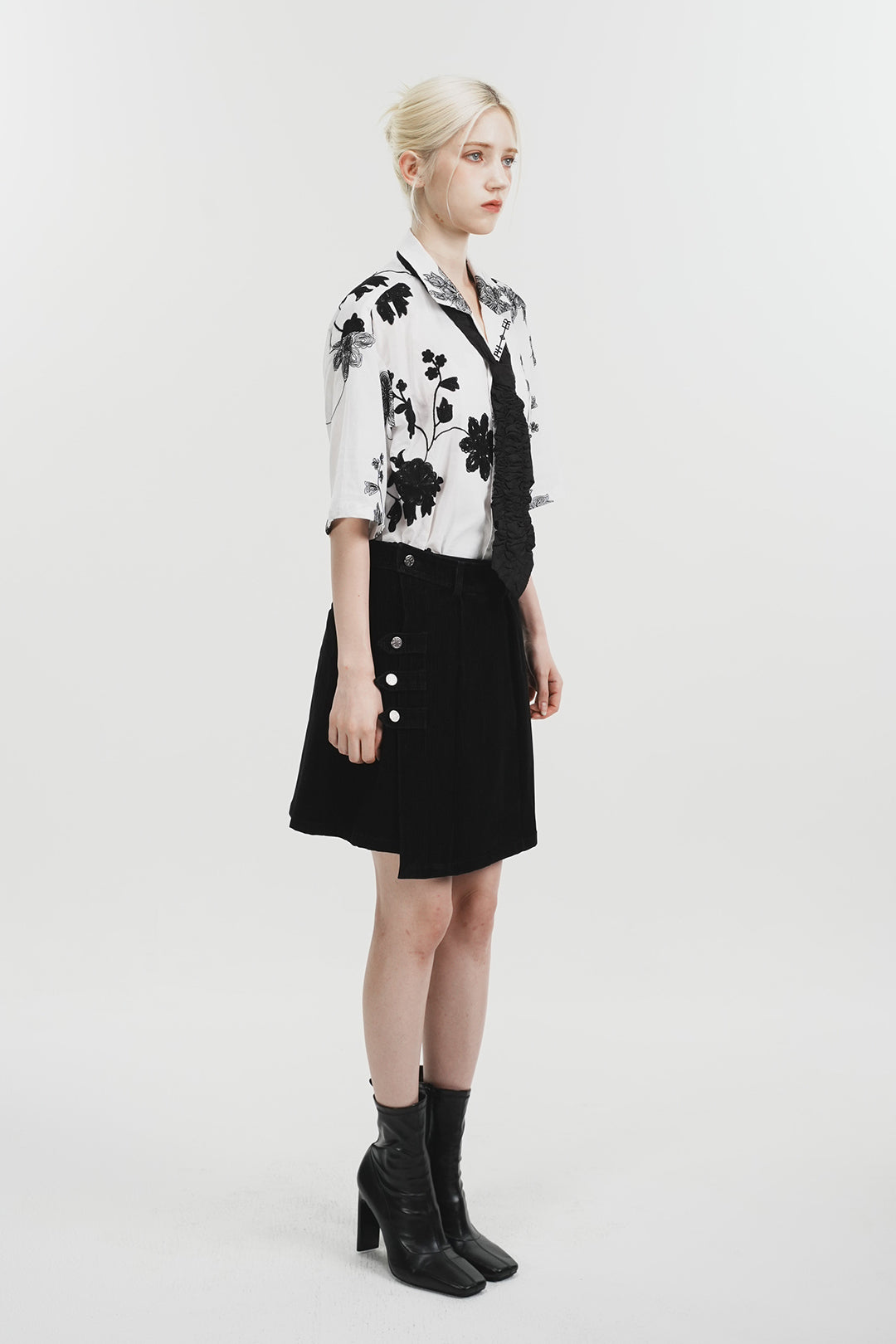 White Phenomenon Seeper Unbalance Flower Half Shirt with a relaxed fit and floral design, displayed on a hanger.