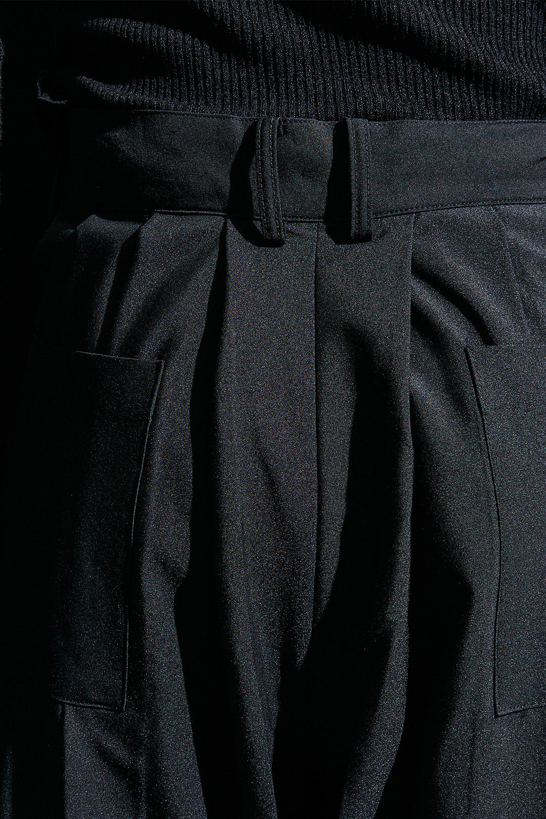 Black wide pleated pants from Reculer, featuring a relaxed fit and pleated design, shown on a model.