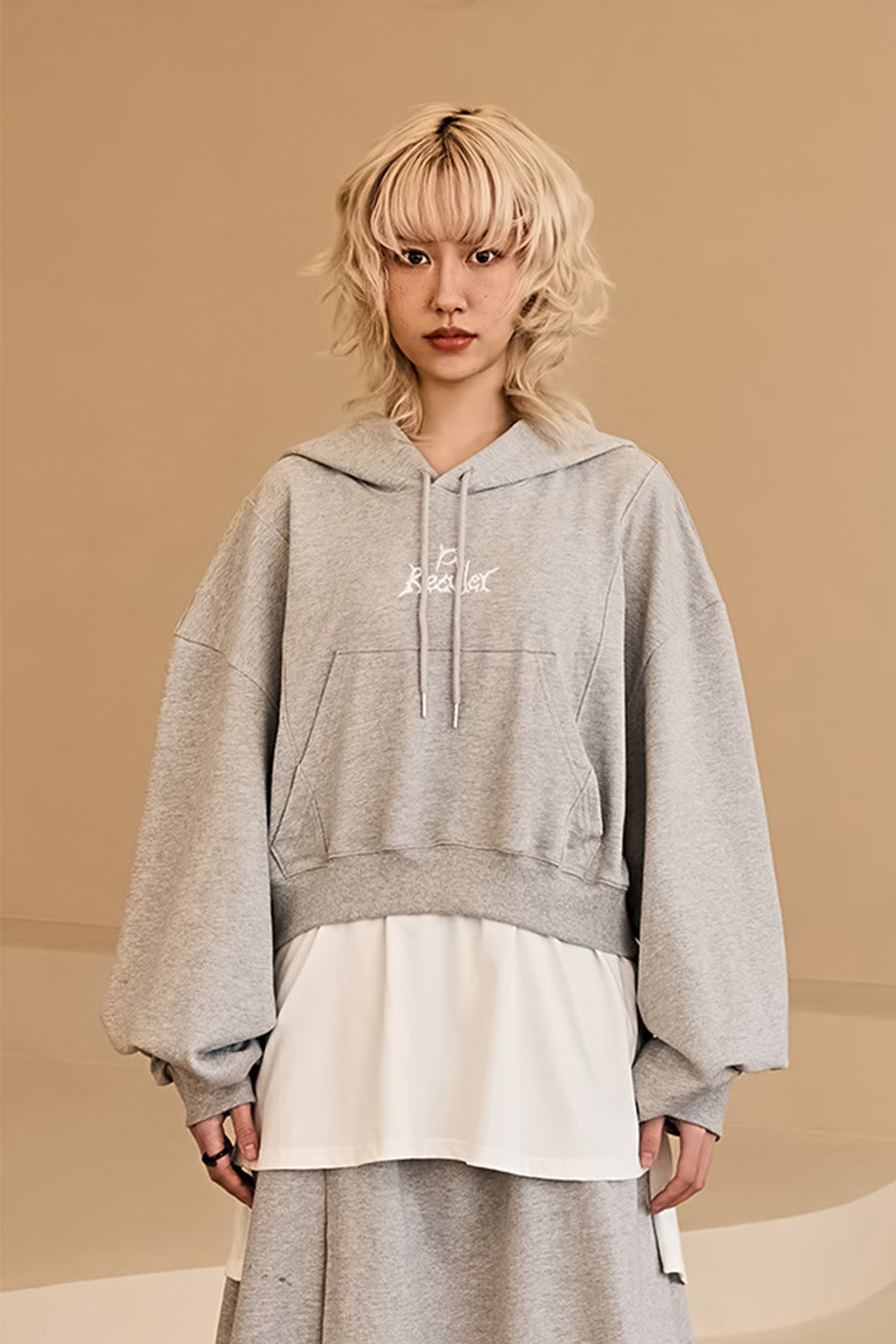 Reculer layered grey hoodie with a relaxed fit, featuring a stylish, multi-layered design and a comfortable hood.