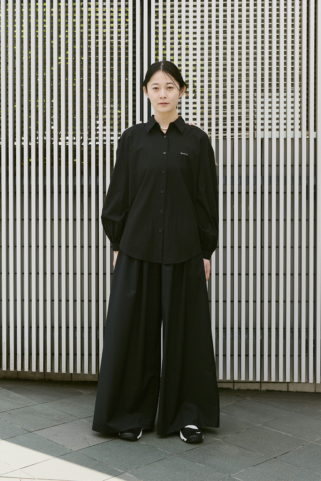 Black Ribbon Wings Ribbon Shirt by EUNJO featuring a stylish ribbon design and tailored fit, displayed on a hanger.