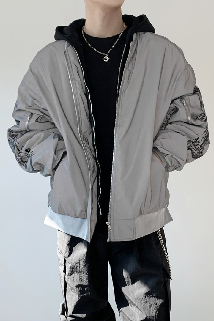Black TM3 bomber jacket with grey fabric, dragon embroidery, and reflective accents, featuring a sleek, modern design.