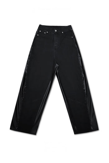 Unisex TM3 Dokkaebi Flame black denim leather pants with wide unbalanced fit and flame design, front view.