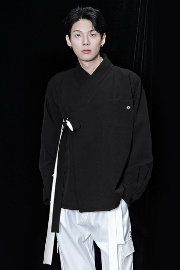 Black oversized shirt from TM3, relaxed fit, long sleeves, and classic collar, displayed on a hanger.