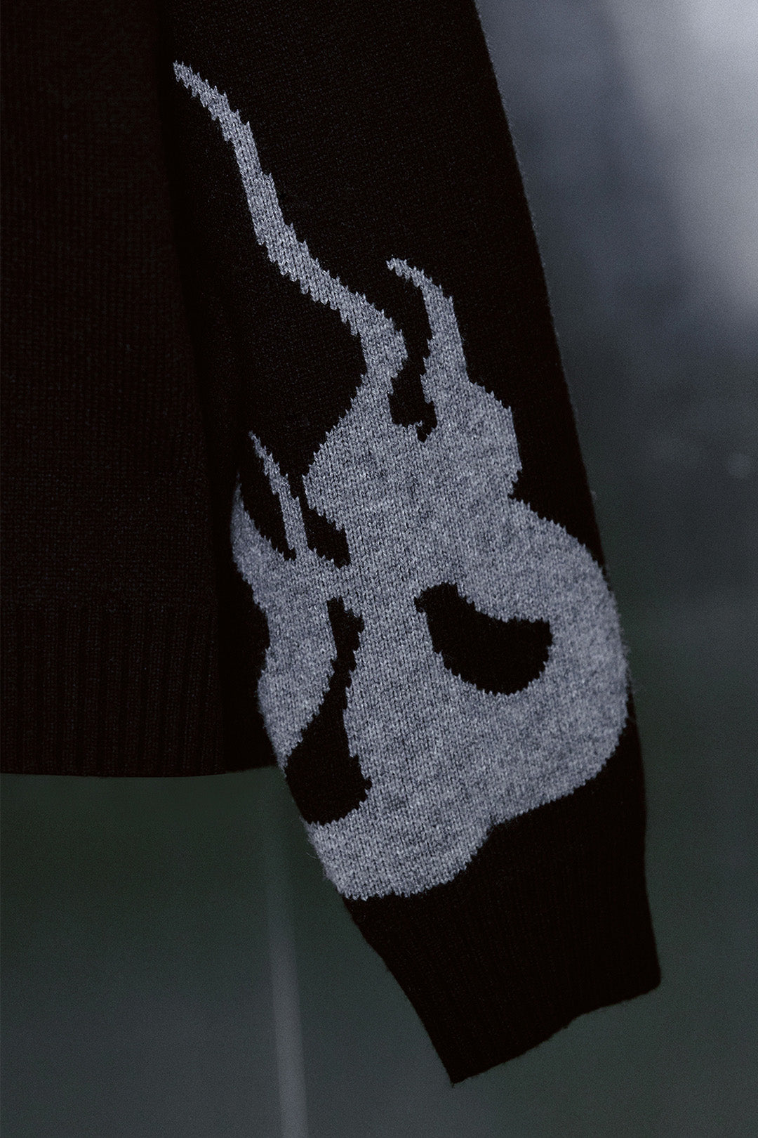 Black TM3 traditional Korean Dokkaebi face Merino wool knit sweater showing detailed knit pattern and facial design.